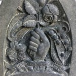 hand grasping flowers gravestone memorial