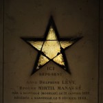 yellow star shaped stained glass window in Paris cemetery mausoleum tomb